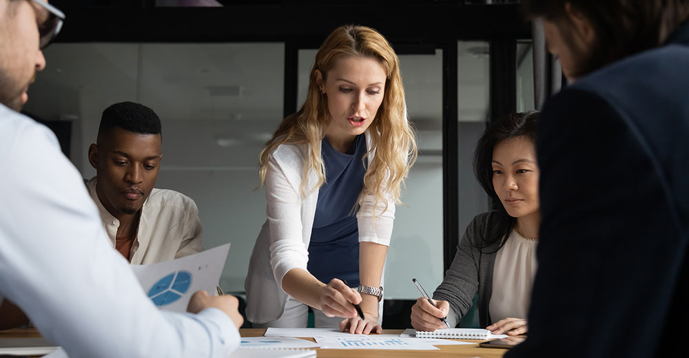 A CRM team collaborates to guide workflow decisions, reflecting a human-in-the-loop approach to AI.