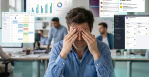 Overwhelmed office worker surrounded by multiple workplace software dashboards and notifications illustrating digital workplace overload