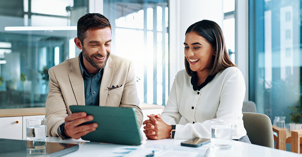 Manager and employee reviewing performance data together on a tablet during a one-on-one meeting